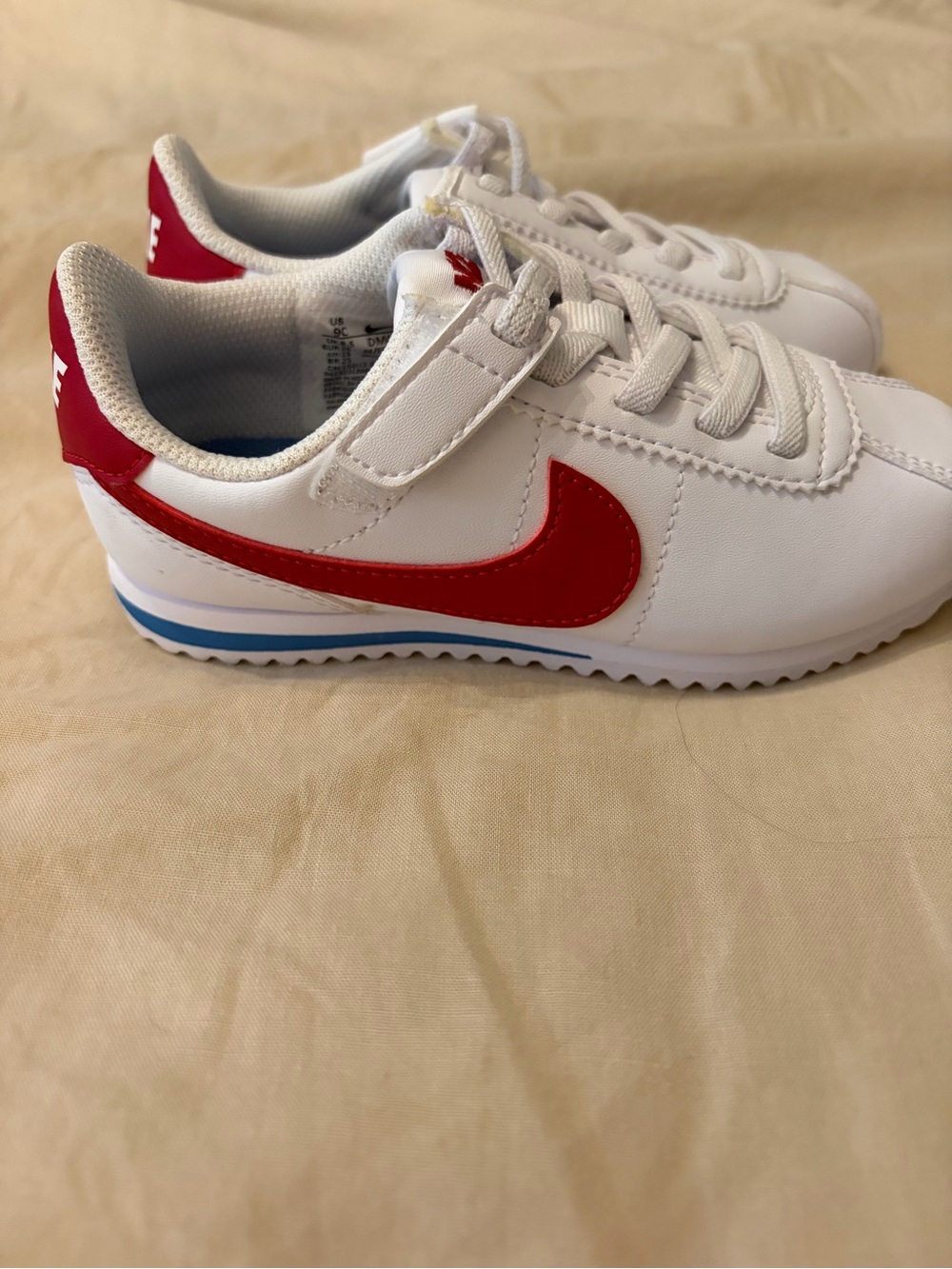 Nike Kids White Sneakers with Red Swoosh and Blue Stripe